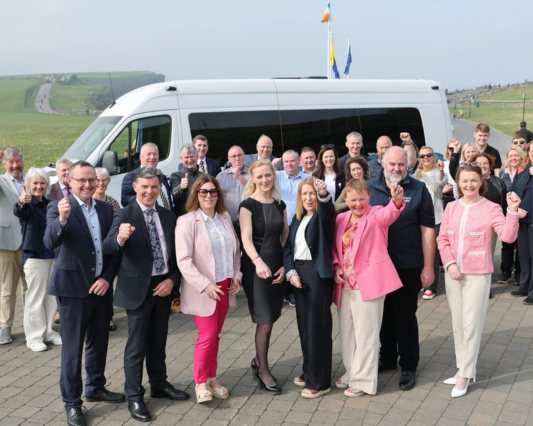 People standing in front of the Burren & Cliffs Explorer Shuttle Bus in 2025